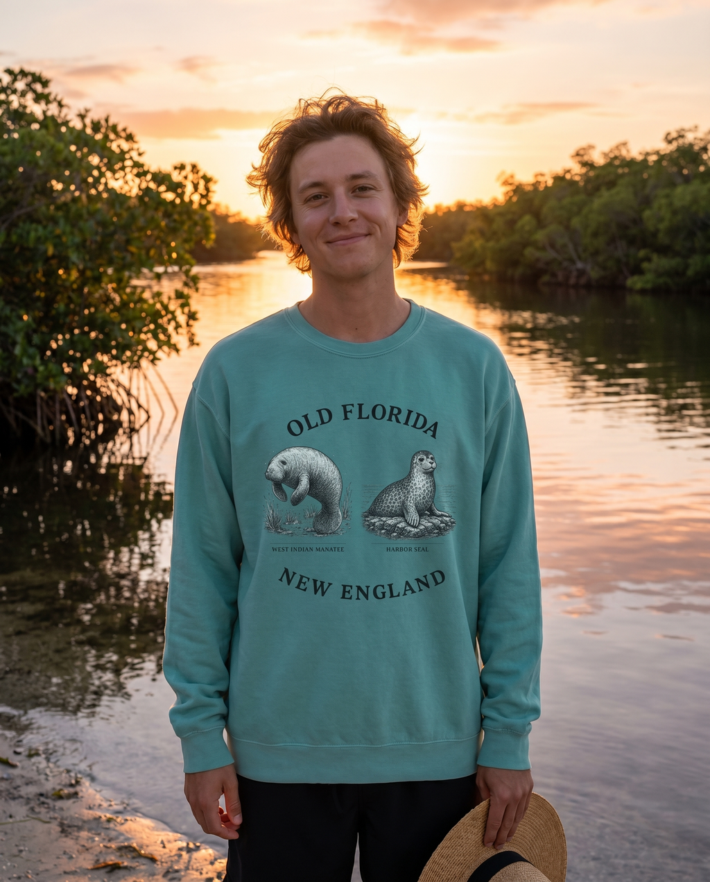 Manatee and Seal Sweatshirt — front design visible, person at Florida waterway at sunset